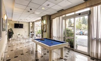 a pool table is in the middle of a room with chairs and tables around it at Hotel Europa