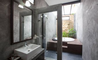 a modern bathroom with a walk - in shower , bathtub , and a sink , all situated in a modern interior space at Chalicha Resort
