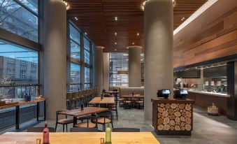a modern restaurant with wooden tables , chairs , and stools , as well as a bar area at Hyatt Regency Seattle