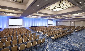 a large conference room with rows of chairs and a stage , ready for an event at Sheraton Grand Seattle