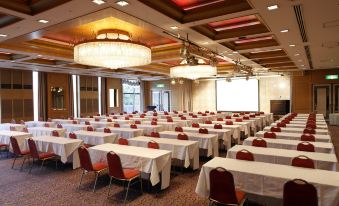 a large conference room filled with rows of tables and chairs , ready for a meeting or event at SHIROYAMA HOTEL kagoshima