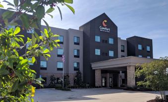 a large , modern hotel building with the comfort inn logo prominently displayed on the front at Comfort Inn & Suites