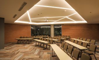 a large conference room with multiple rows of chairs arranged in a semicircle around a long table at Four Points by Sheraton Puebla