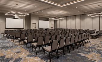 a large conference room with rows of chairs arranged in front of a projector screen at Crowne Plaza North Augusta
