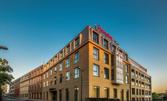 "a modern building with a red sign that reads "" krankenhaus "" is shown against a clear blue sky" at Hampton by Hilton Oswiecim