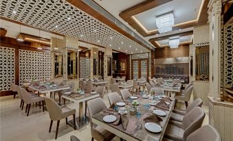 a large , well - decorated dining room with multiple tables and chairs arranged for a group of people at The Fern Residency Aurangabad