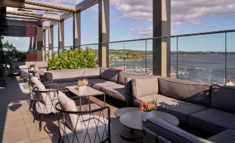 a rooftop terrace with a view of the city , featuring comfortable seating and dining areas at Radisson Blu Caledonien Hotel, Kristiansand