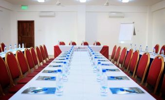 a long dining table set up for a meeting , with chairs arranged around it and bottles of water placed on the table at Nungwi Beach Resort by Turaco