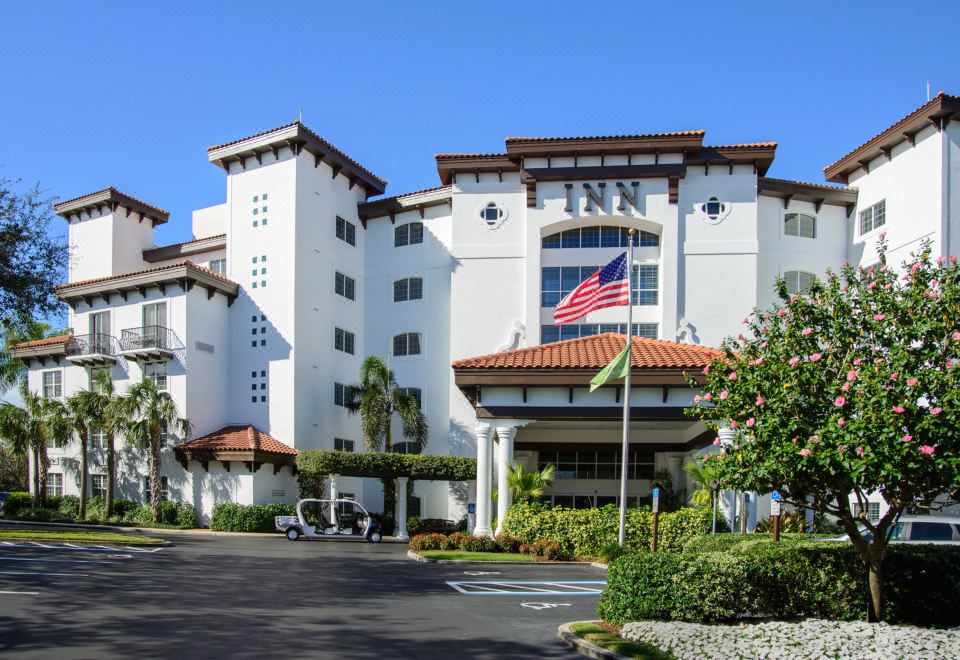 a large white building with an american flag on top , surrounded by a parking lot at Inn at Pelican Bay