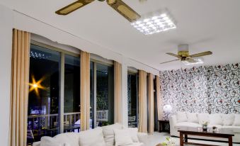 a large white couch is in a room with two tables and a ceiling fan at Hotel Royal