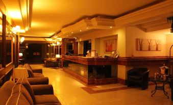 a hotel lobby with a reception desk , couches , and chairs arranged in a comfortable seating area at Hotel Frontera Clasico