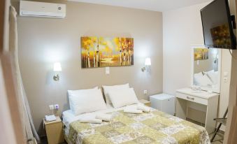a modern bedroom with a bed , nightstands , and lamps , as well as a tv and air conditioning unit at Lux Hotel