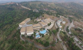 aerial view of a large building surrounded by trees and mountains , with a pool in the foreground at Timberland Highlands Resort