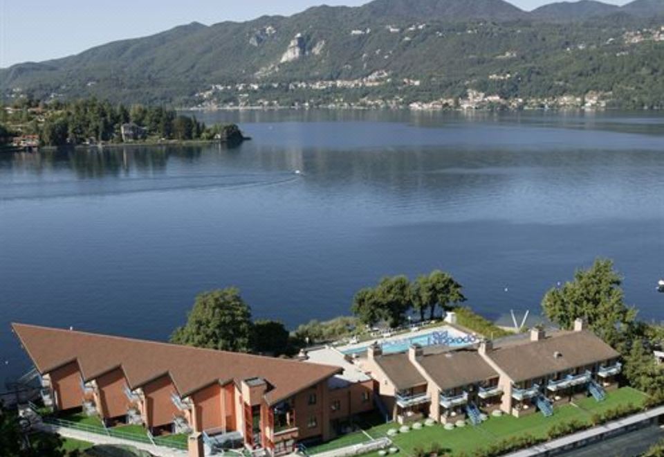 aerial view of a large lake surrounded by mountains , with a hotel on the shore at Hotel l'Approdo