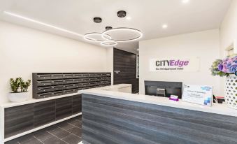 "a reception area with a desk and chairs , as well as a sign that reads "" cityedge ""." at City Edge Box Hill Apartment Hotel