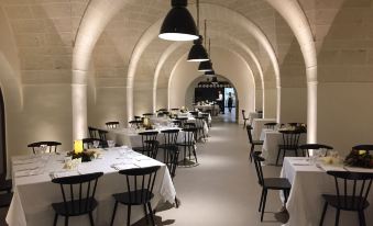 a large dining room with tables and chairs arranged for a group of people to enjoy a meal at Masseria Amastuola Wine Resort