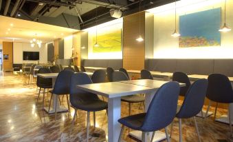 a modern restaurant with a long dining table and several chairs , creating an inviting atmosphere for guests at Hub Hotel