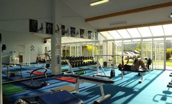 a well - equipped gym with various exercise equipment , including weights and cardio machines , under the sun at Wairakei Resort Taupo