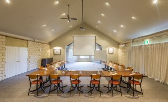 a conference room set up for a meeting , with tables and chairs arranged in a semicircle at Hanmer Springs Retreat