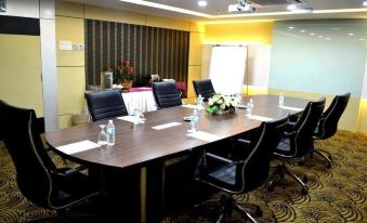 a conference room set up for a meeting , with a long wooden table and chairs arranged in a semicircle at De Rhu Beach Resort