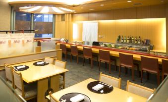 a restaurant with wooden tables and chairs , a long counter with bottles , and large windows at Hotel Nikko Kansai Airport