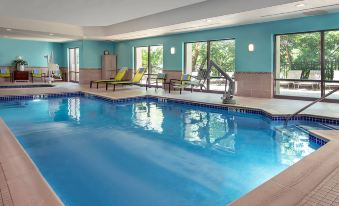 a large swimming pool with a slide and lounge chairs is surrounded by blue walls at SpringHill Suites Centreville Chantilly