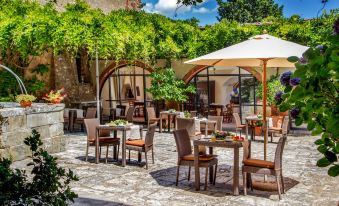 an outdoor dining area with tables , chairs , and an umbrella set up for a meal at Abbadia Sicille Relais