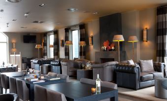 a modern lounge area with a large window , couches , and several dining tables with chairs at Fletcher Hotel - Restaurant Nautisch Kwartier