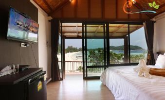 a bedroom with a large bed and sliding glass doors leading to an outdoor area at Chareena Hill Beach Resort