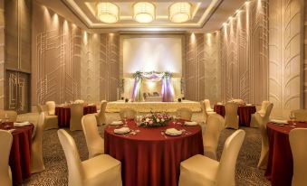 a well - decorated banquet hall with round tables and chairs arranged for a formal event , possibly a wedding reception at Courtyard Ahmedabad