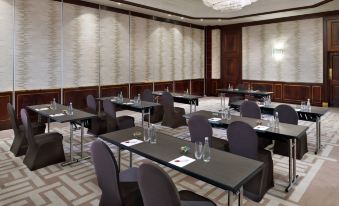 a conference room set up for a meeting , with multiple tables and chairs arranged in rows at Amman Marriott Hotel
