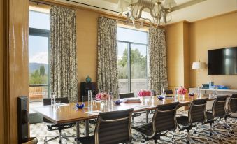 a conference room with a long table , chairs , and floral centerpieces , set up for a meeting at Rosewood Sand Hill