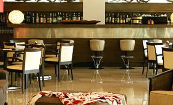 a dining room with a table and chairs , as well as a bar area with various bottles and glasses at Hotel Antonios