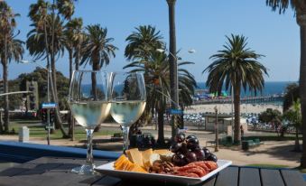 a table with two wine glasses , a plate of food , and a view of the beach at Ocean View Hotel