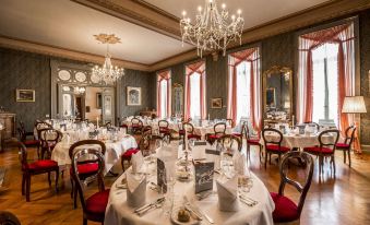a large dining room filled with tables and chairs , ready for guests to enjoy a formal dinner at Grandhotel Giessbach