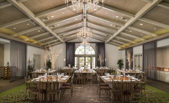 a large , well - lit dining room with multiple tables and chairs set up for a formal event at Bernardus Lodge & Spa
