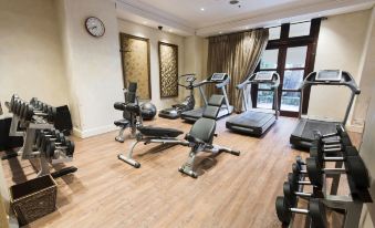 a well - equipped gym with various exercise equipment , including treadmills and weightlifting machines , in a spacious room at Palazzo Hotel