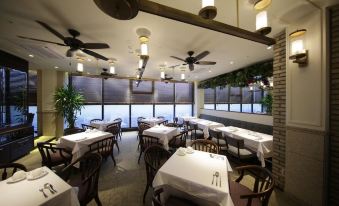 The restaurant features tables and chairs, large windows that overlook the outdoor seating area in the dining room at Solaria Nishitetsu Hotel Seoul Myeongdong