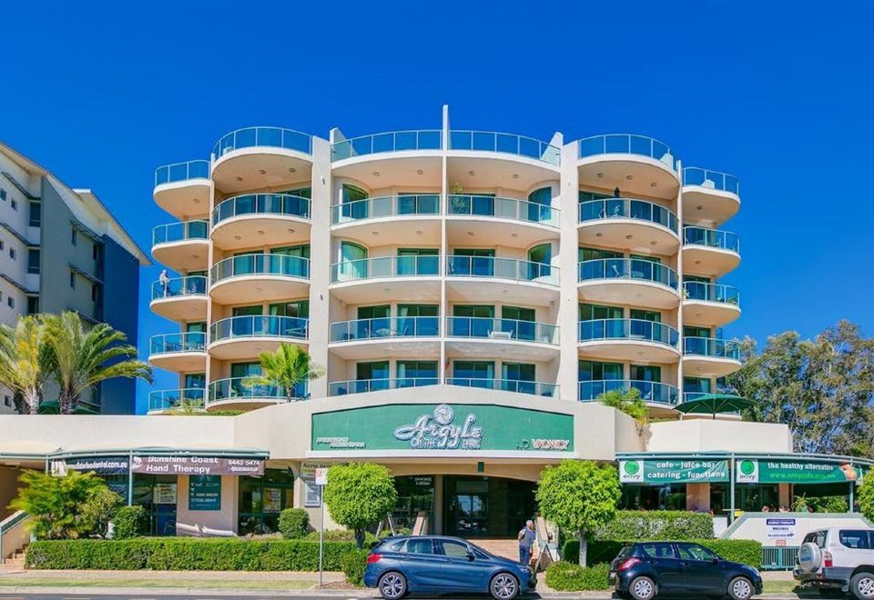 a large hotel with multiple stories and balconies , situated on a street corner near the ocean at Argyle on the Park