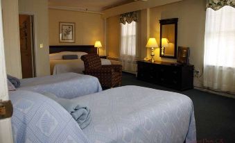 a hotel room with two beds , a dresser , and lamps , giving it a cozy and inviting atmosphere at Hotel Coolidge