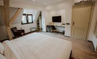 a modern bedroom with a white bed , black and brown furniture , and a flat - screen tv mounted on the wall at Republique