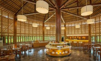 a large dining room with wooden furniture , including tables and chairs , and a long wooden pole in the center at Alba Wellness Resort by Fusion
