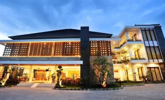 a large , modern building with a parking lot in front of it , illuminated at night at Kautaman Hotel