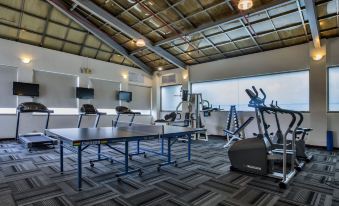 a large , well - equipped fitness center with various pieces of exercise equipment , including treadmills , elliptical machines , and ping pong tables at Carlton Hotel