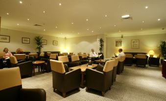 a large room filled with chairs and couches , some of which are occupied by people at Holiday Inn Leeds - Wakefield M1, Jct.40