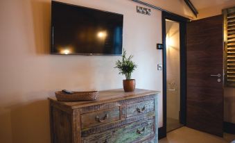 a small room with a wooden dresser , a television mounted on the wall , and a potted plant at Charter House