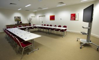 a conference room with a long table , chairs , and a few paintings on the wall at Quest Mawson Lakes