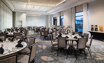 a large dining room with multiple tables and chairs arranged for a group of people to enjoy a meal together at Crowne Plaza North Augusta