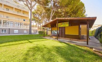 "a small building with a sign that says "" montserrat "" is surrounded by green grass and trees" at Mll Palma Bay Club Resort