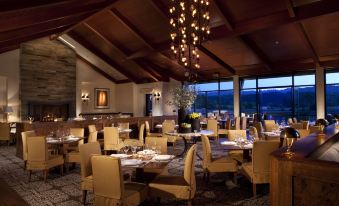a large dining room with wooden tables and chairs arranged for a group of people to enjoy a meal together at Rosewood Sand Hill